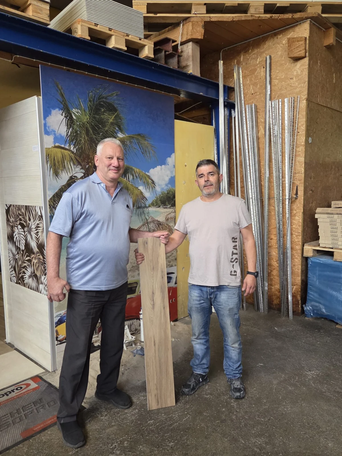 Gilbert Tschanz und Senco Siegenthaler mit einer Platte in Holzoptik